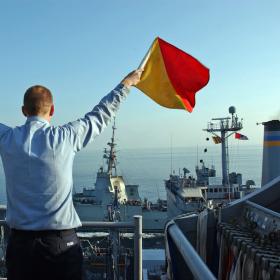 Crewman holding semaphore flags