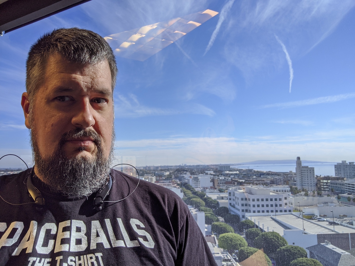 Selfie of me in front of a window in Ziprecruiter HQ looking out over Santa Monica.