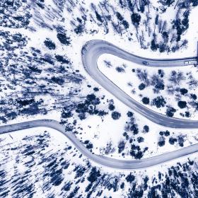 an aerial view of a winding road in the snow