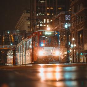 light rail train on a street at night